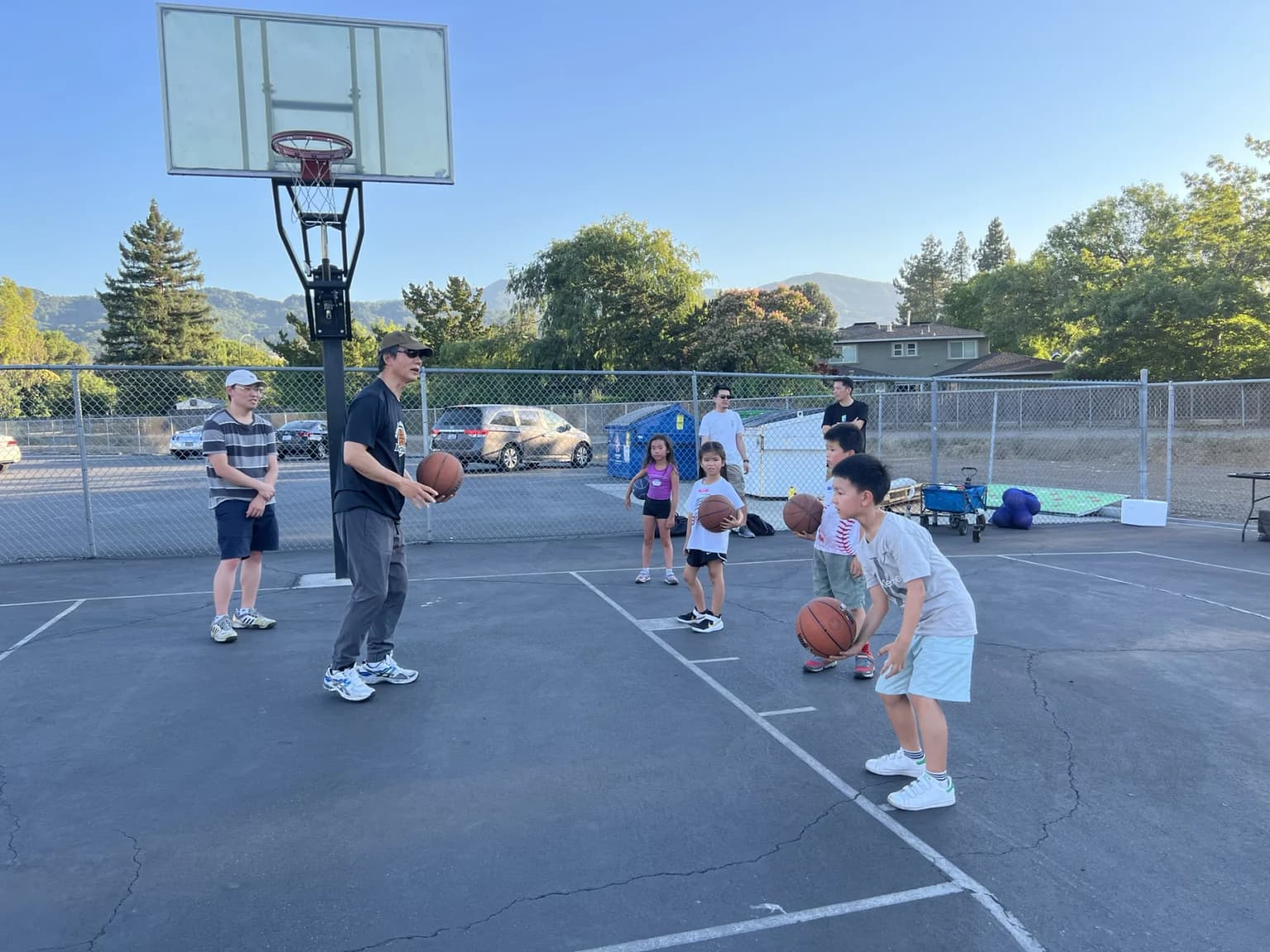A coach teaching young boys basketball fundamentals.