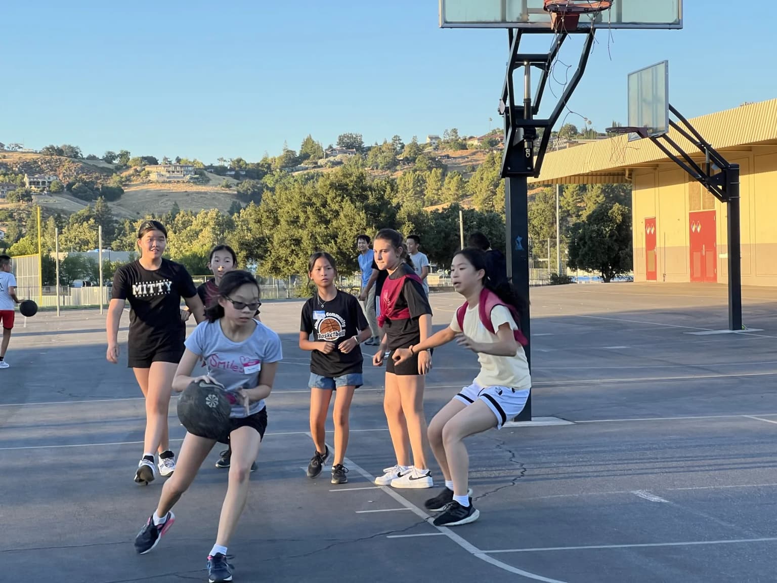 Girls playing basketball during an outdoor ACB session.