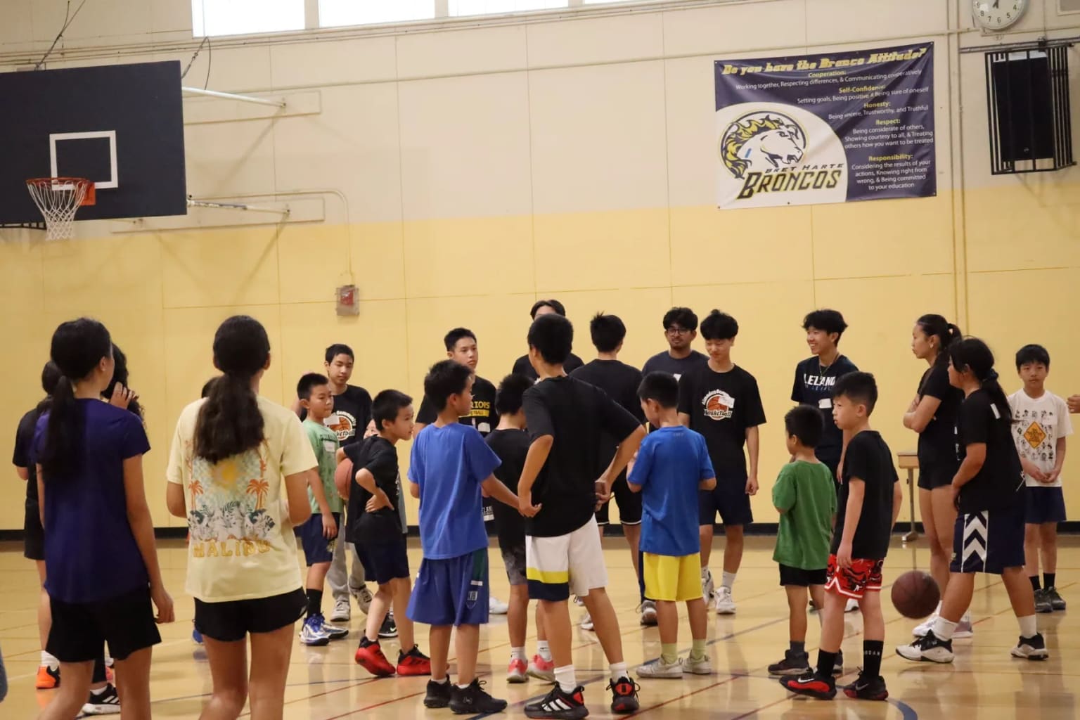 Campers listening to a coach in the gym.