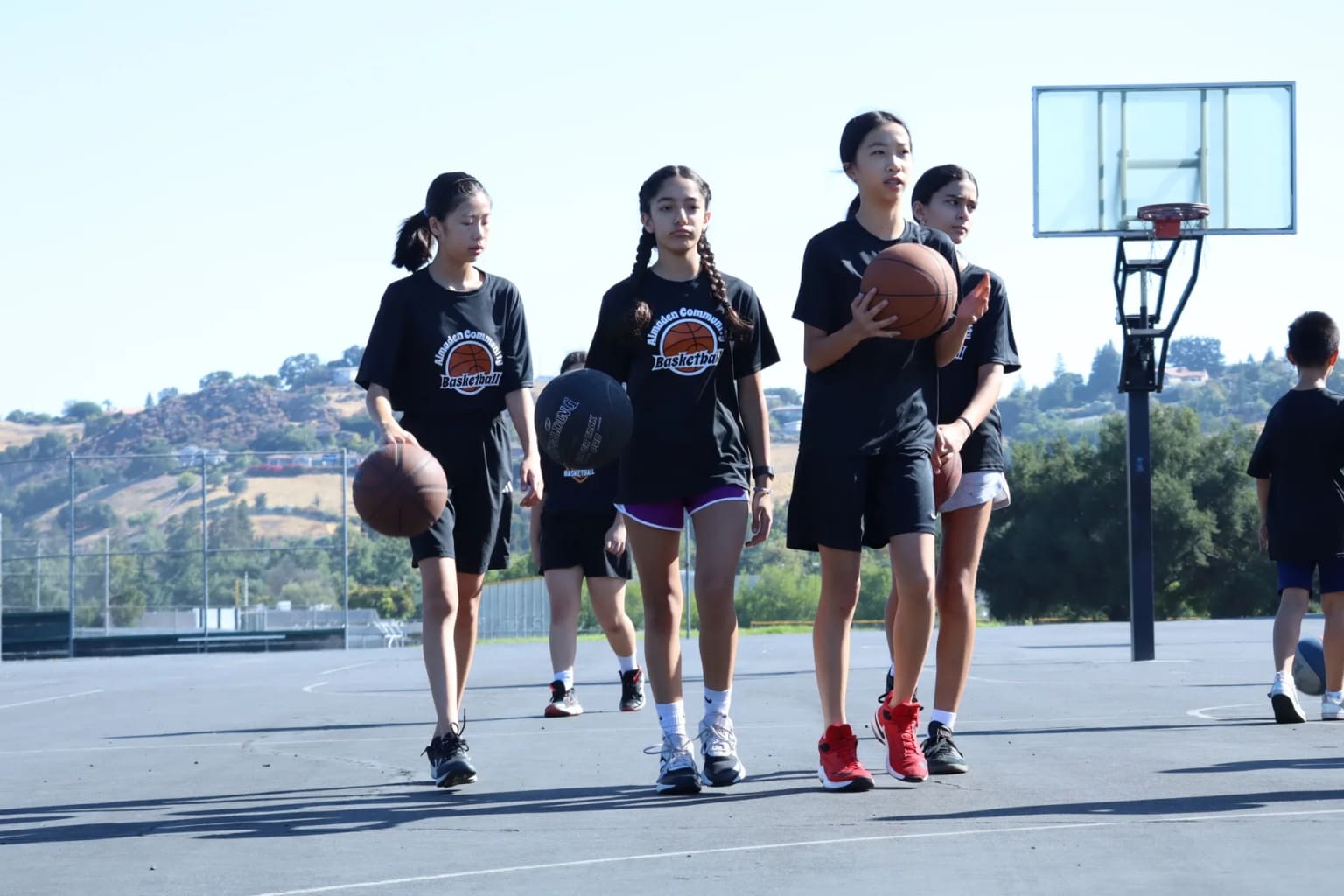 Girls participating in an outdoor basketball camp.